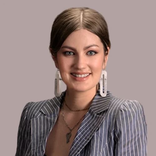 Whitney, wearing a pinstriped blazer and statement earrings, smiling confidently